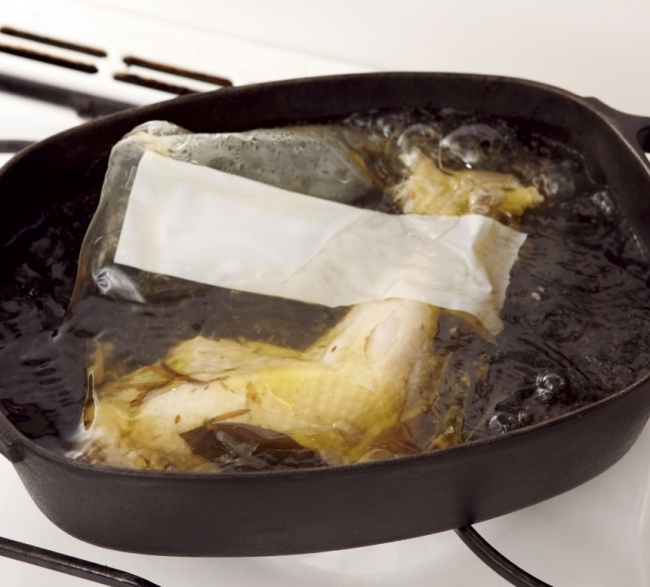 ①チキンが入る大きな鍋にお湯を沸騰させ、チキンを開封せずパックのまま入れ、弱火で約20分間温めます。