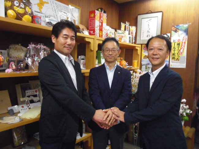 ３者で握手 左から、宇和島プロジェクト・木和田社長、愛媛県営業本部　八十島（やそしま）本部長、ロッテ広報部・岡林課長