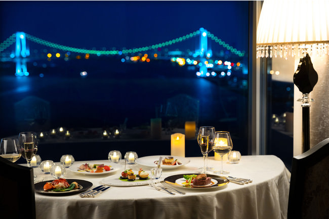 窓辺にセッティングされたテーブルから臨むロマンティックな夜景