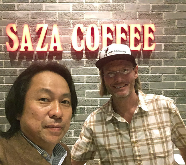 ロングボード農園のジャスティン氏と鈴木太郎。壁に今までに訪れたゲイシャコーヒーの生産者の名前もちろんジャスティン氏も